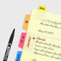 ultra tabs placed in yellow paper notebook next to marker on gray background