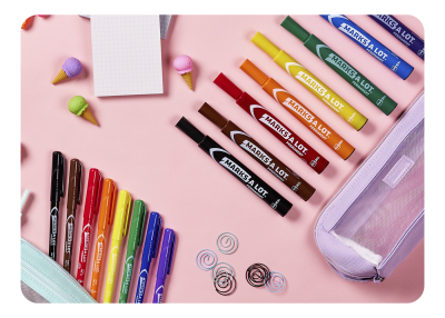 A collection of Avery Marks A Lot markers in a range of different bright colors and different sizes on a pastel pink desk.