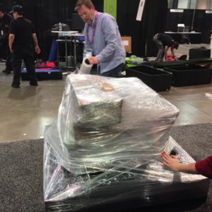 a money-saving trade show idea is to pack, wrap and ship your trade show display yourself as shown by an Avery employee. 