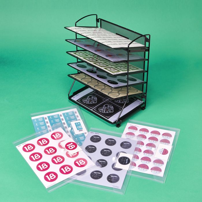 A wire file rack is repurposed to store and organize sheet labels.