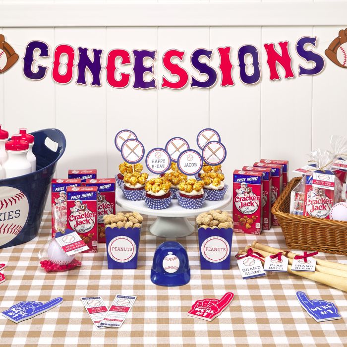 A table for a baseball birthday is set up with many themed party ideas. There are mini bats personalized with Avery tags, cupcakes with DIY toppers made from Avery labels and other treats labeled with Avery tags or labels.