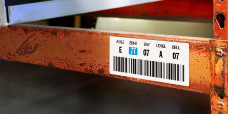 inventory shelving labeled with location information and a barcode