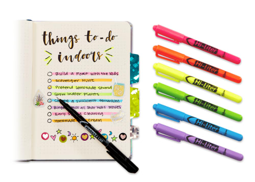 Flatlay of a colorful bullet journal decorated by Avery highlighters in a rainbow of colors sitting next to it