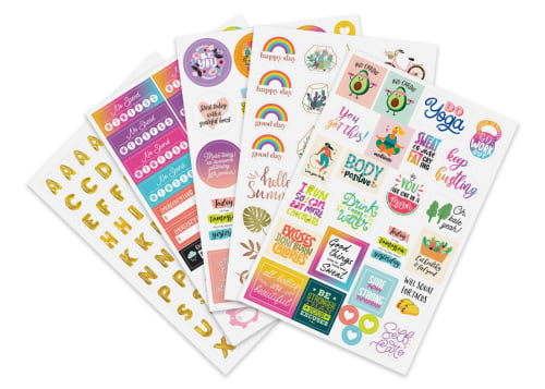 Flatlay of fanned out planner sticker sheets in various colors, shapes and sizes with several motivational messages.