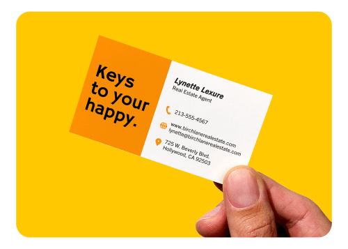 A hand holding a custom printed Avery business card with real estate branding.