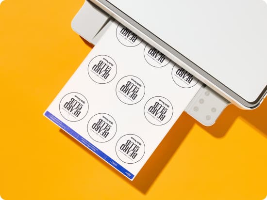 Blank Labels being printed on a home printer for small business packaging; printable product labels shown on yellow background.