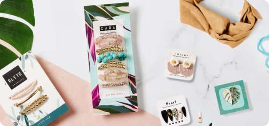 Five different jewelry display cards, two holding sets of bracelets, another two holding sets of earrings, and one with a monstera leaf pendant.