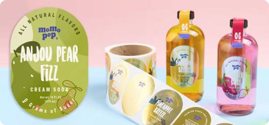 Two bottles of shampoo in pineapple and strawberry scents, sitting next to a roll of shiny and colorful labels. On the left is a close up of one of the brand's pear labels, showcasing the scent with various shades of green and a illustrations of pears.