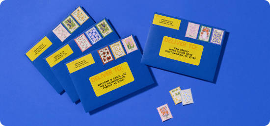 Blue envelopes labeled with yellow Avery address labels that were generated and printed with Avery Design and Print.