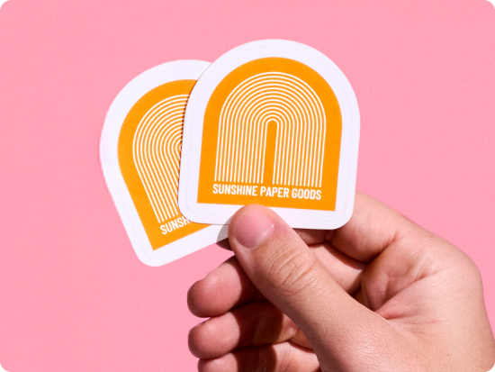 Custom Stickers with colorful logo artwork for marketing promotions; promotional stickers for businesses on pink background.