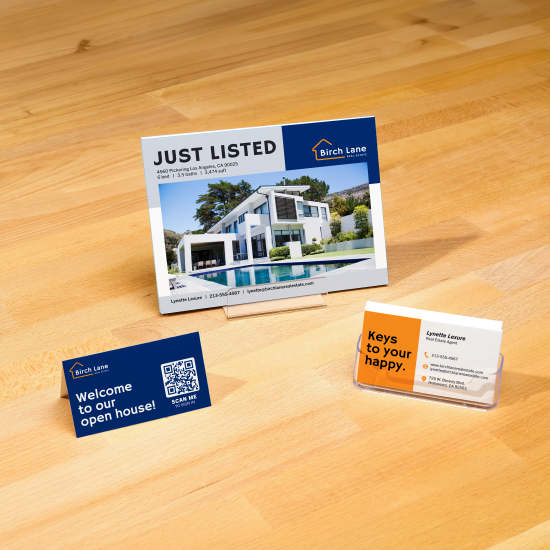 A wooden table with Avery cards custom printed with real estate branding.