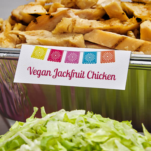 Avery place card 16109 showing a potluck idea for a fiesta or Day of the Dead theme. The design features colorful papel picado and the card reads, "Vegan Jackfruit Chicken."