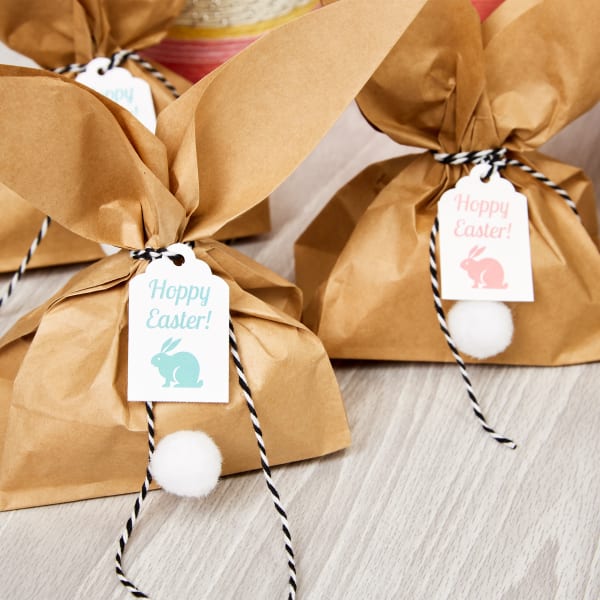 Brown paper lunch bags cut to look like bunny ears at the top with a cotton "tail glued on and Avery 22848 tags that read "Hoppy Easter."