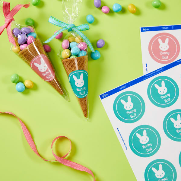 Adorable Easter treat using an ice cream cone filled with pastel candies and wrapped in plastic with a bow. Avery 22807 labels with "Bunny Bait" Easter templates printed on them complete the treat idea.