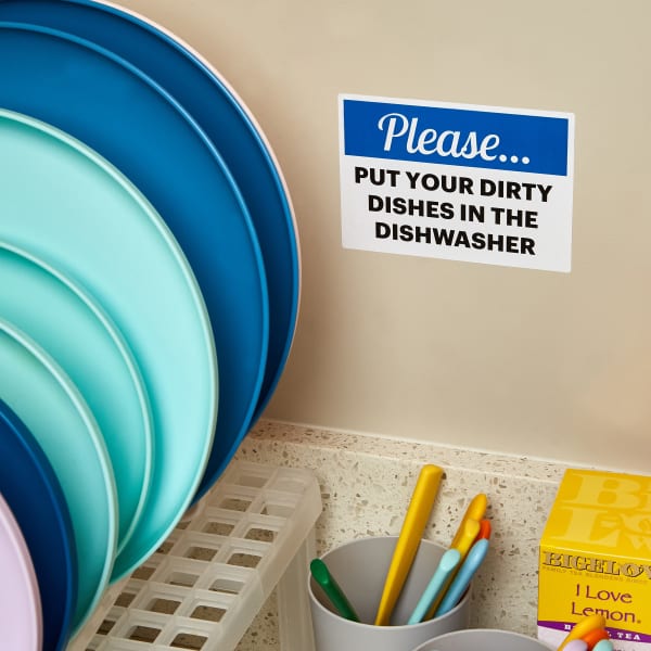 An office kitchen etiquette message shown above a kitchen sink. The message is on an Avery Surface Safe adhesive sign. 