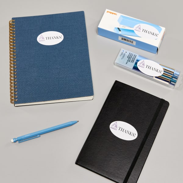 A group of notebooks and writing supplies branded with oval Avery labels 22564.
