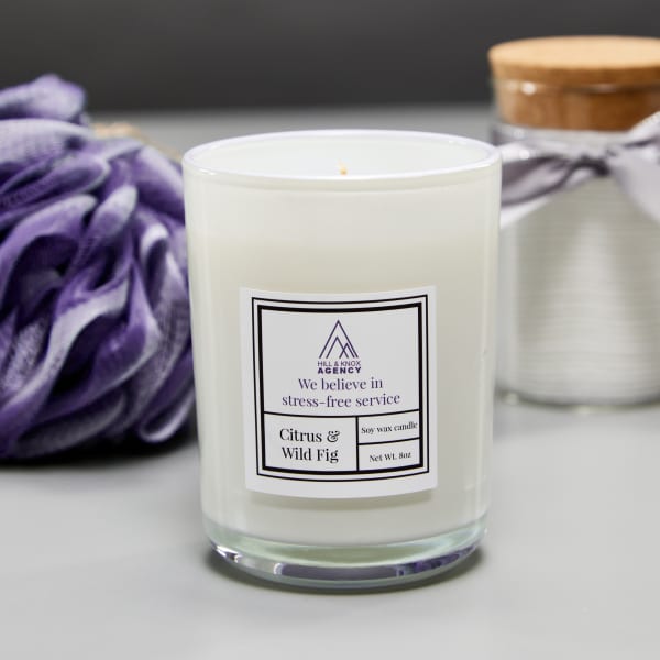 A candle and other bath products are grouped together for self-care theme. The candle features Avery waterproof label 64503 customized with branding. 