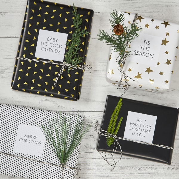 Modern gift wrapping idea with black, white, and gold color scheme and simple square labels with simple text. 