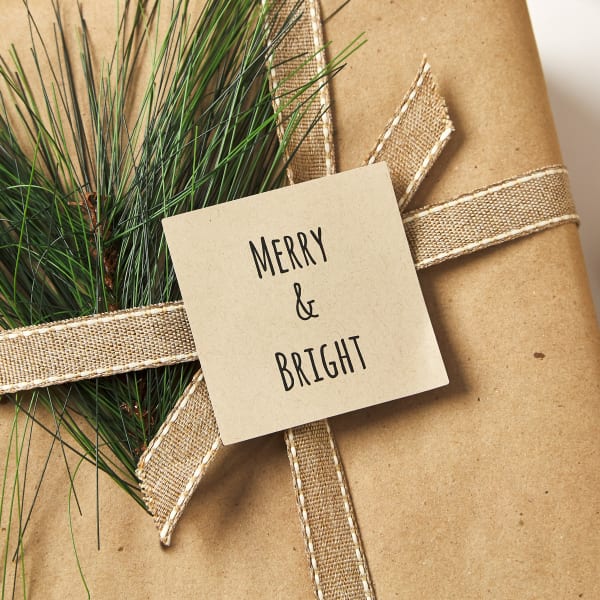 Rustic gift wrap idea with Kraft paper labels and wrapping paper accented with fresh pine sprigs. 