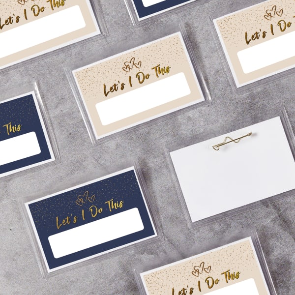 A simple, elegant wedding name tag idea that reads, "Let's I Do This." the design is shown with either beige or navy blue backgrounds, gold font, and a space to handwrite names.