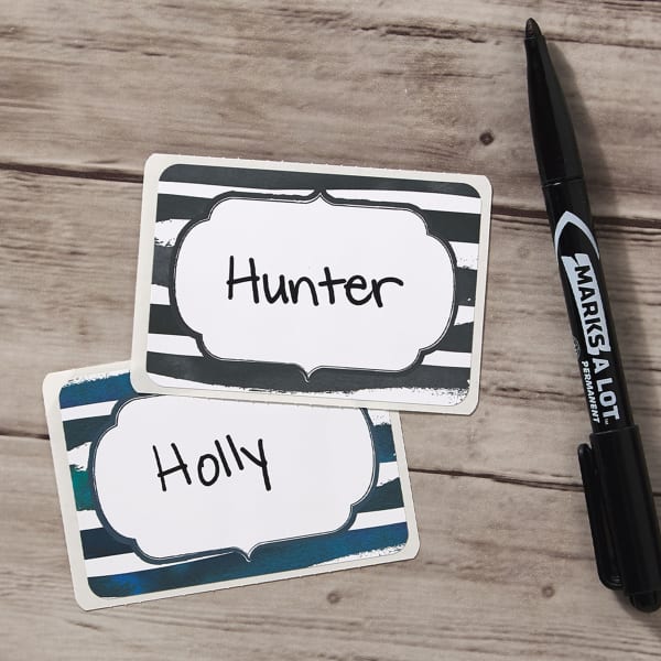 Examples of a bold, modern party name tag idea that just features thick stripes with a unique shape in the center for handwriting individual names.