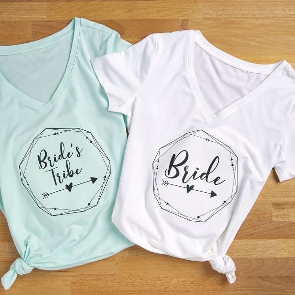 Two V neck t-shirt party favors for a bridal shower or bachelorette party. Both shirts are personalized with Avery 3271 iron-on fabric transfers. One reads, "Bride," and the other reads, "Bridesmaid."