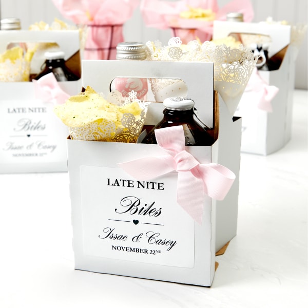 Examples of snack box wedding favors for guests. Each box with a handle is filled with two bottled beverages and two paper cones filled with snacks. The boxes are labeled with Avery 5164 labels that read, "Late Nite Bites" personalized with the bride and groom names and the wedding date. 