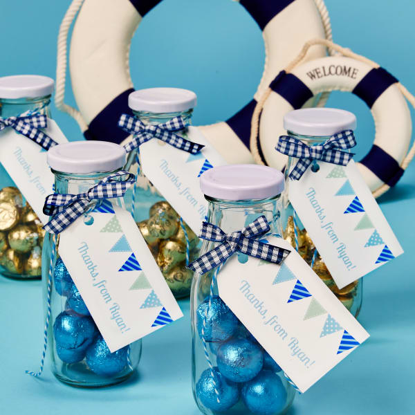 Color-coordinated candy is added to jars for a personalized effect. The favors are topped off with personalized Avery 22802 tags with a blue bunting design.