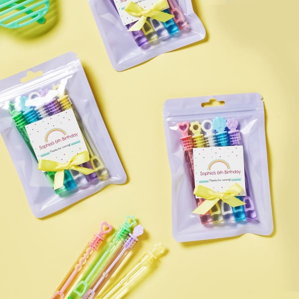 Pastel mini-bubble wands are added to lavender bags and topped off with a personalized rainbow-themed label. The labels are printed on Avery 22806 square labels.