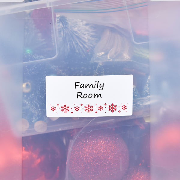 A template for 2" x 4" Christmas storage labels that reads "family room" and is decorated with red snowflakes. 