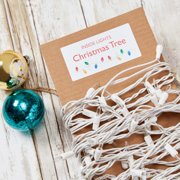 A DIY example of how to organize Christmas lights by wrapping them around cardboard and labeling the cardboard. 