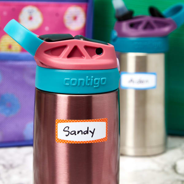 A close up a kid's metal water bottle that is labeled with Avery durable and dishwasher safe 41442 label. The label features a polka dot border and is has the name, "Sandy," written on it by hand. 