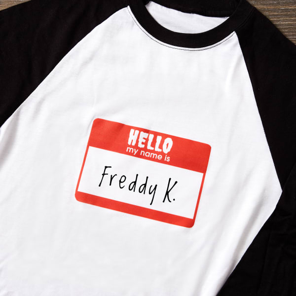 A black and white raglan tee with a "Hello My Name Is" fabric transfer design that's personalized with "Freddy K." for Halloween.