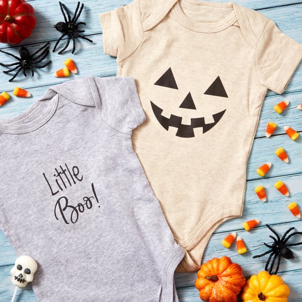 Two Halloween templates on baby onesies. One is cute text that reads "Little Boo!" and the other is a jack o' lantern face. 