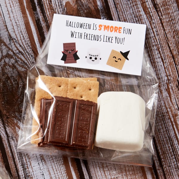 Halloween bag topper idea made with Avery place cards 5302. The design features a cute cartoon chocolate vampire, marshmallow Frankenstein's monster and a graham cracker witch and reads, "Halloween is s'more fun with friends like you."