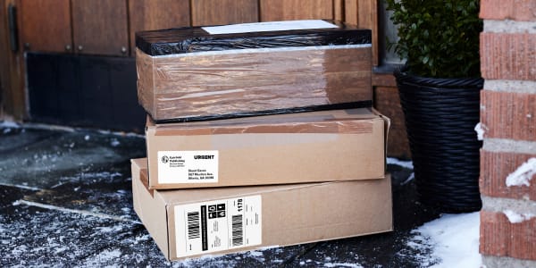 Image of delivered packages on snow covered porch. Packages have Avery waterproof shipping labels attached made from Avery 5524 and Avery 15516.