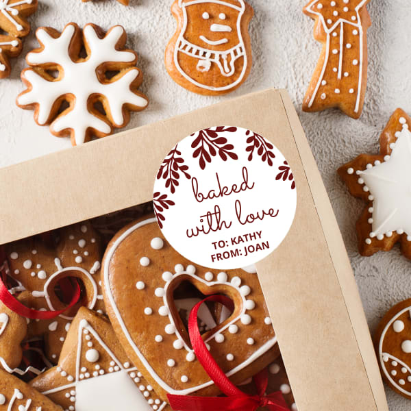 "Baked with Love" Christmas cookie gift label is printed on round Avery label 22807. There are elegant branches and the words "baked with love" with to and from beneath. 