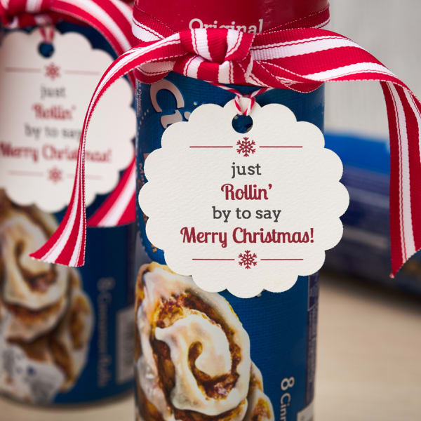 Punny cinnamon roll coworker gift tag is printed on Avery 80511 round scalloped tag. It reads, "Just rollin' by to say Merry Christmas!"