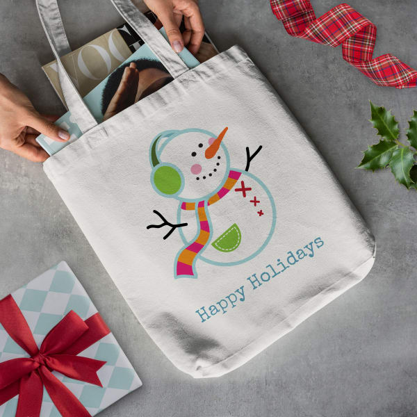 "Happy Holidays" snowman tote bag gift made with a canvas tote and Avery fabric transfer 3271. It shows a cheerful snow man with the words "Happy Holidays."