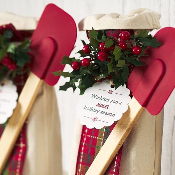 "Wishing You a Sweet Holiday Season" tag printed on Avery tag 80511. The gift is a bag of baking supplies with a spatula and the tag reads "Wishing you a sweet holiday season."