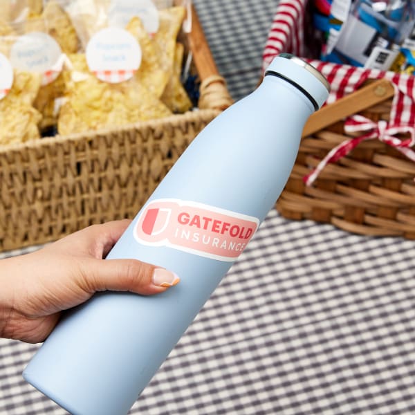 Eight Avery die-cut vinyl stickers with a company logo on them are laid out on a rustic burlap background. 