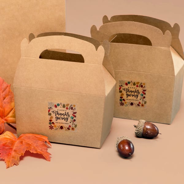 A brown box for leftovers decorated with a clear, square label with a Thanksgiving-themed design.