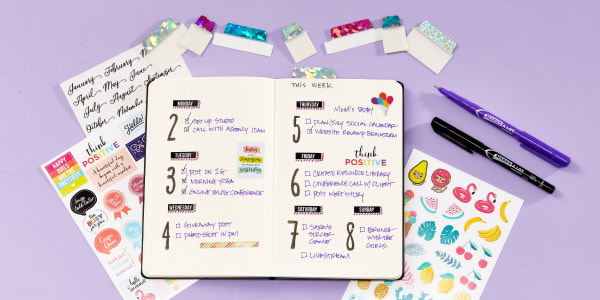 An open planner surrounded with Avery planner stickers, Luxe Collection Ultra Tabs, and Marks-A-Lot markers.