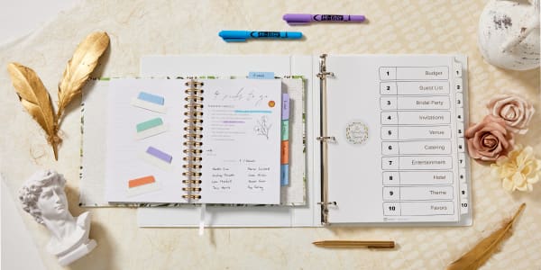 Image showing open Avery binder and planner with wedding planning notes and materials. Inside the binder is a table of contents showing different wedding categories while the open planner has Ultra tabs along the side.