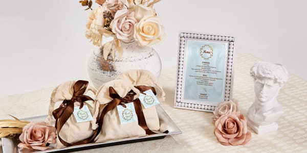 Image showing wedding gift bag favors and menu cards using Avery products. Square gift tag on favor and menu card have coordinating light blue and gold designs.