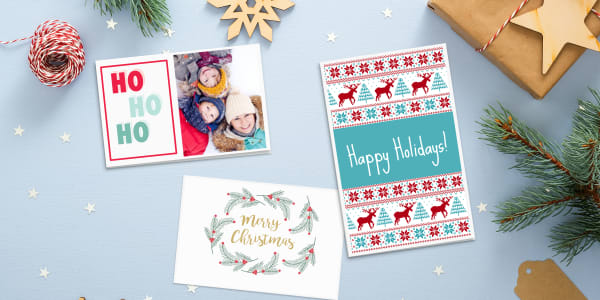 Image of quick Christmas card ideas using three predesigned templates made from free Avery card templates. The holiday cards are  shown on a pale blue and white Christmas background.