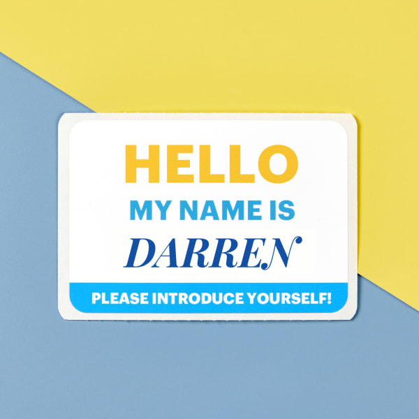 Avery adhesive name tag 25395 with a customizable onboarding template printed on it. The name tag is shown on a blue and yellow background that matches the design. 