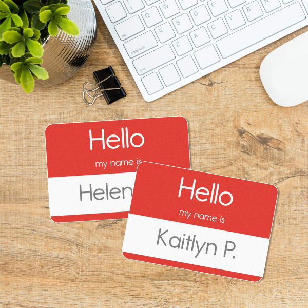 An example of name tags made with Avery 8395 and a free Avery template. The template is a bold red with the iconic "Hello My Name Is" design. Individual names have been added to each name tag sticker before printing. 