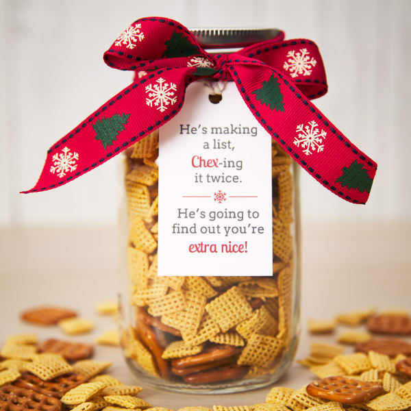 "Chex-ing his list" Mason jar gift idea showing a jar filled with savory Chex mix and decorated with a bow. The jar is also decorated with an Avery 22802 tag which reads "He's making a list, Chex-ing it twice. He's going to find out you're extra nice!"