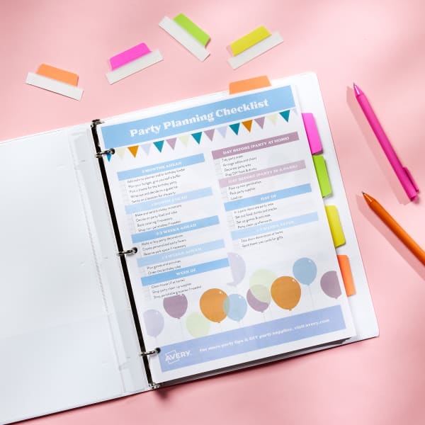 An Avery binder used for party planning is open on a pink tabletop. The first page in the binder is a party-planning checklist. The contents of the binder are marked with colorful neon UltraTabs.